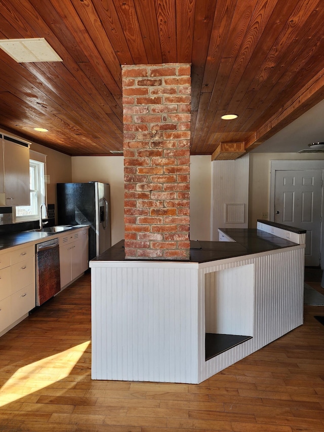 kitchen featuring dark countertops, appliances with stainless steel finishes, and hardwood / wood-style floors