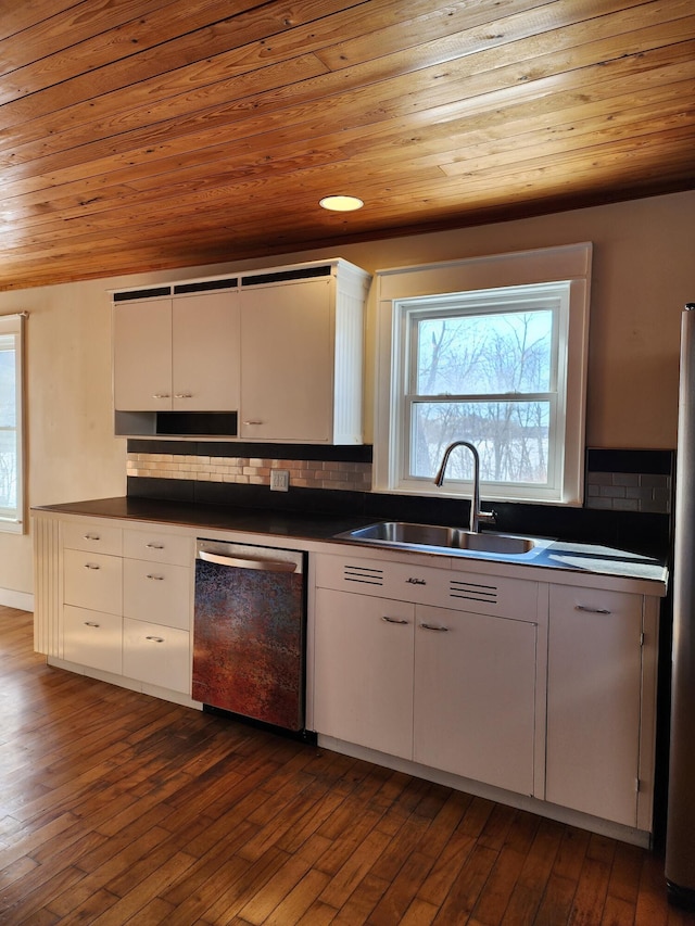 kitchen featuring decorative backsplash, appliances with stainless steel finishes, dark wood-style flooring, and a sink