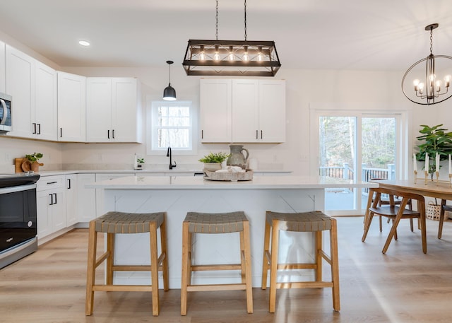 kitchen with white cabinetry, a breakfast bar area, and a center island