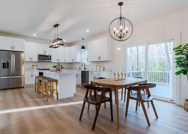 kitchen with hanging light fixtures, white cabinets, and appliances with stainless steel finishes