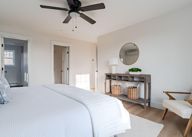 bedroom featuring ceiling fan, a baseboard radiator, and light hardwood / wood-style flooring