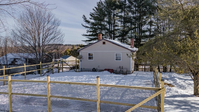 view of snow covered back of property