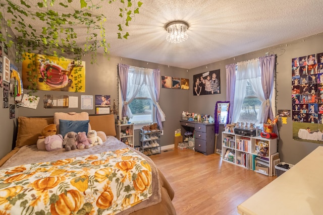 bedroom with light hardwood / wood-style flooring and a textured ceiling