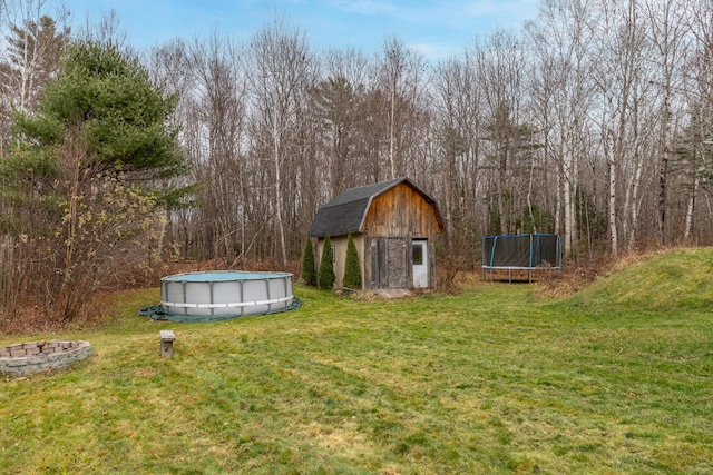 view of yard with a trampoline and a storage unit