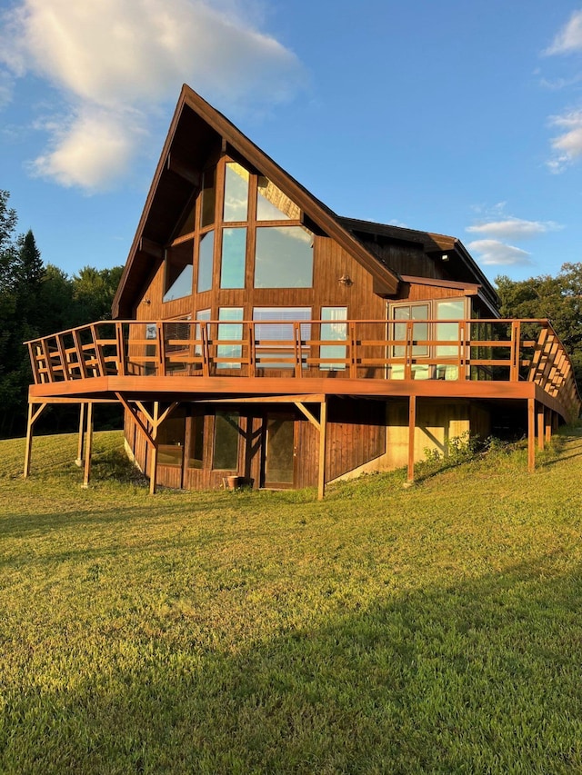 rear view of house with a lawn and a deck