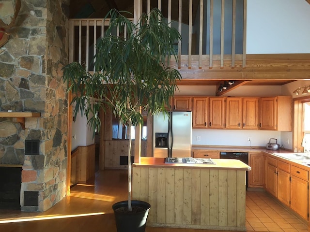 kitchen with light tile patterned floors, a fireplace, and black appliances