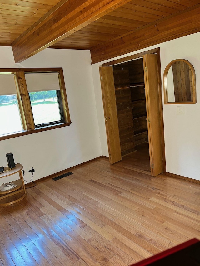 unfurnished bedroom featuring wood ceiling, light hardwood / wood-style flooring, and beamed ceiling