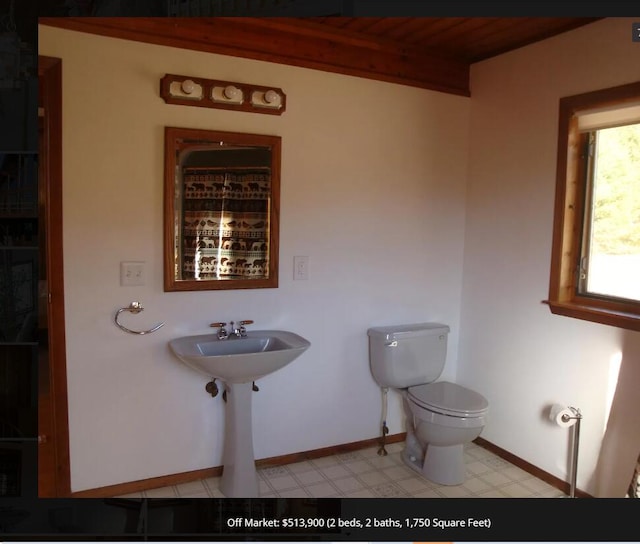 bathroom featuring toilet and beamed ceiling