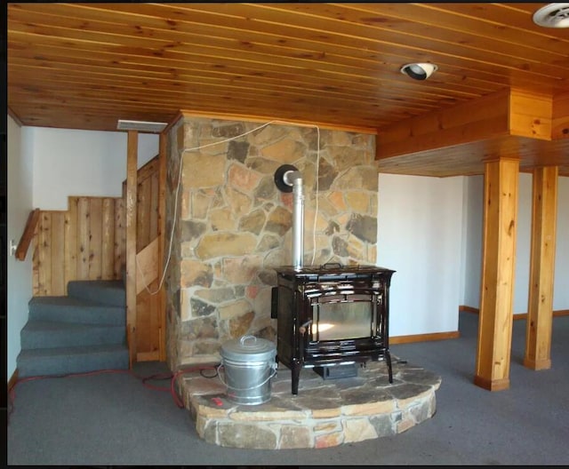 interior details featuring wood ceiling and a wood stove