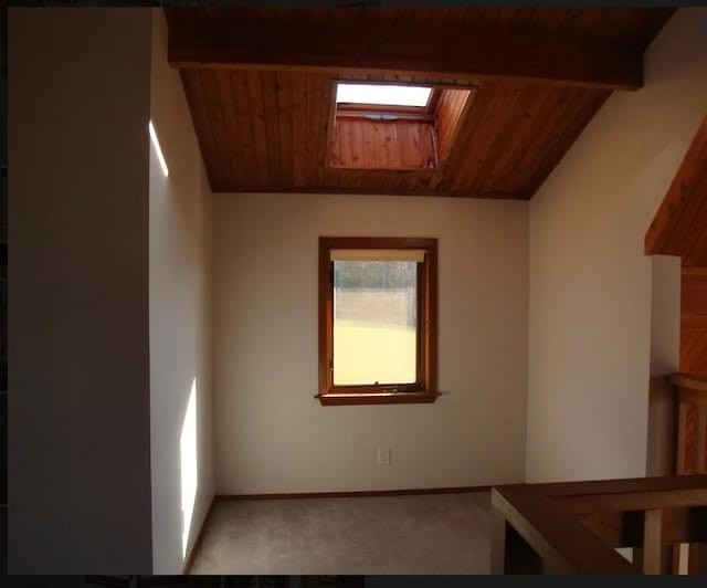 32 Dillon Rd, Harrison, ME 04040 - empty room with carpet, a skylight, wooden ceiling with exposed beams, and baseboards
