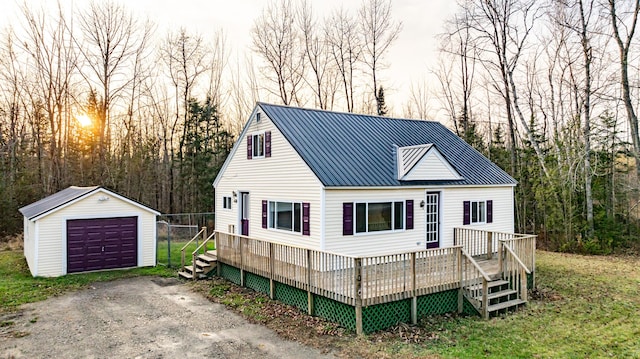 view of front of home featuring a wooden deck, a garage, and an outdoor structure