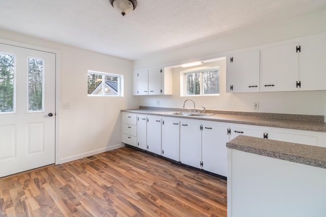 kitchen with white cabinetry, sink, and dark hardwood / wood-style flooring