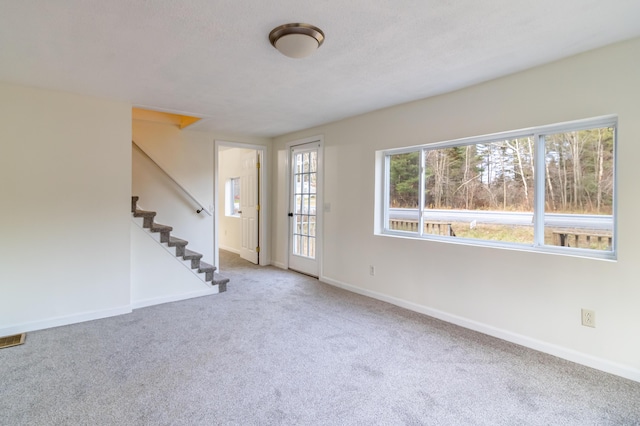 unfurnished room featuring a textured ceiling and carpet flooring