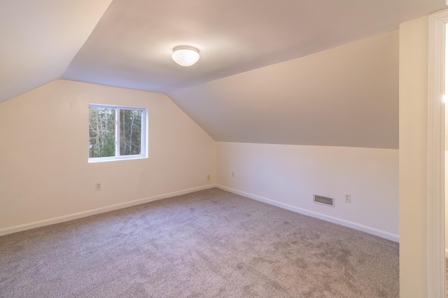 additional living space with vaulted ceiling and carpet floors