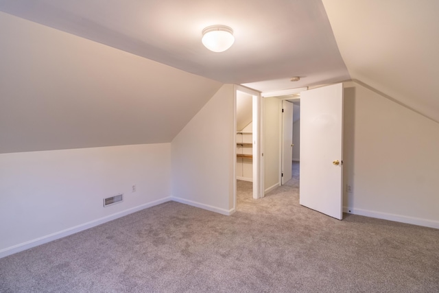 bonus room featuring vaulted ceiling and light carpet