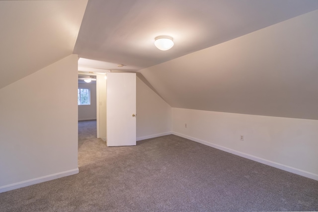 additional living space with lofted ceiling and carpet flooring