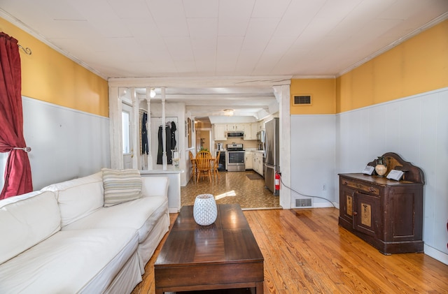 living room featuring light wood-type flooring and crown molding