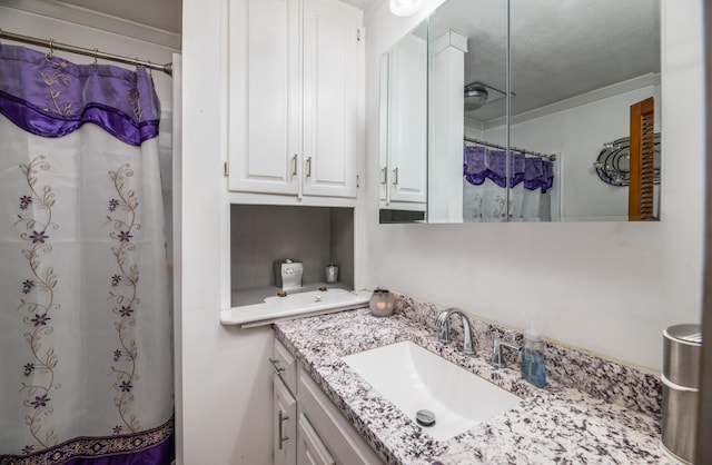 bathroom featuring a shower with shower curtain, vanity, and crown molding