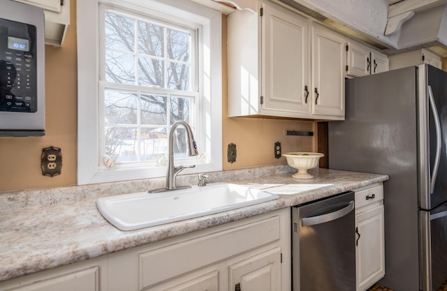 kitchen featuring sink, appliances with stainless steel finishes, and white cabinetry