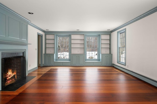 unfurnished living room featuring built in shelves, a baseboard heating unit, ornamental molding, a fireplace with flush hearth, and wood finished floors