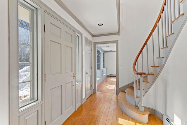 entryway featuring light wood finished floors, stairs, ornamental molding, and baseboard heating