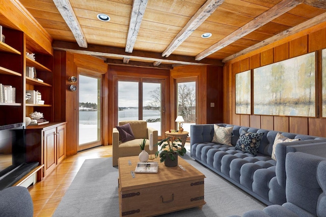 living area with wooden ceiling, a water view, wooden walls, and beam ceiling