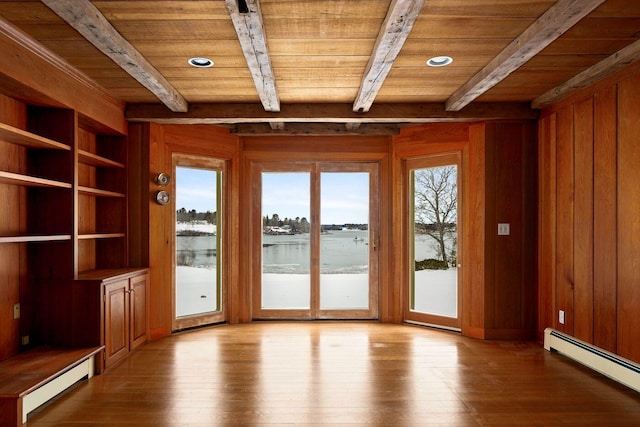 doorway to outside featuring wood ceiling, wooden walls, a baseboard heating unit, and wood finished floors