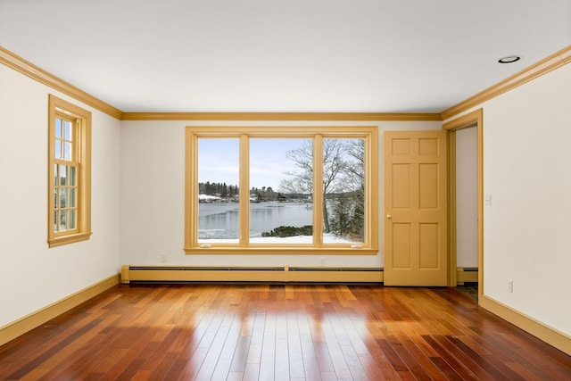 spare room featuring ornamental molding, wood-type flooring, baseboards, and baseboard heating