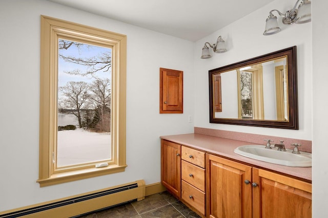 bathroom featuring a baseboard heating unit, vanity, and baseboards