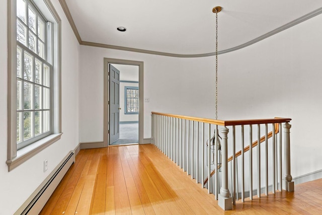 entryway with crown molding, a baseboard radiator, and light wood-style floors