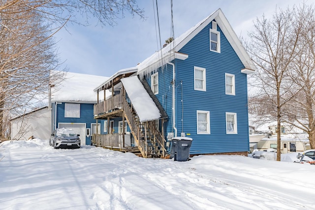 snow covered rear of property with a garage