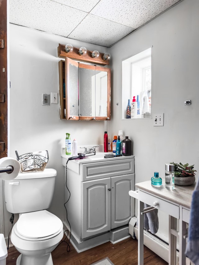 bathroom featuring a paneled ceiling, vanity, toilet, and wood-type flooring