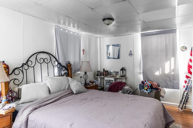 bedroom with hardwood / wood-style floors and a drop ceiling