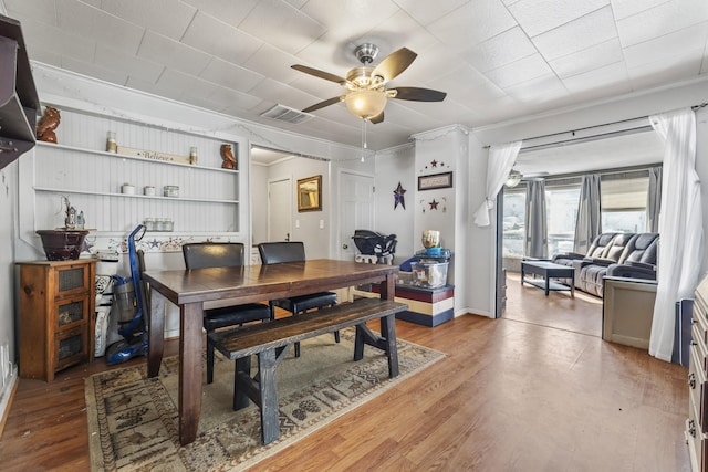 dining area featuring crown molding, hardwood / wood-style floors, and ceiling fan