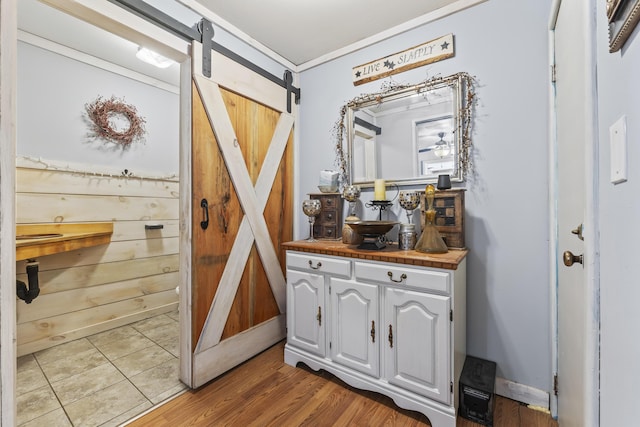 bar with a barn door, tile counters, and white cabinets