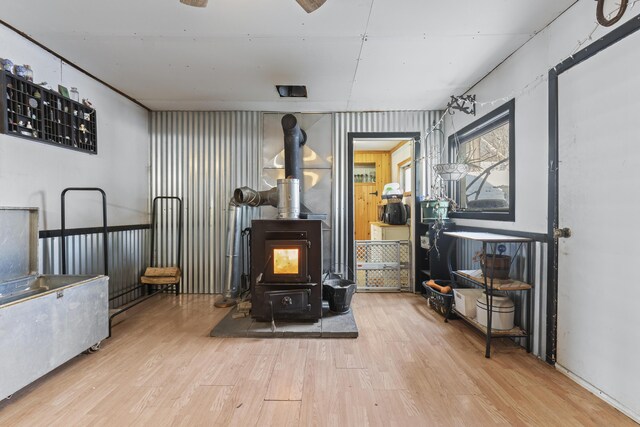 sitting room with a wood stove and light hardwood / wood-style floors