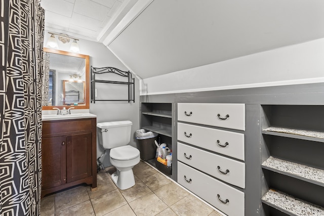 bathroom featuring vanity, vaulted ceiling, tile patterned floors, and toilet