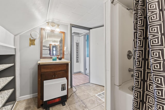 bathroom featuring lofted ceiling, vanity, tile patterned flooring, and shower / tub combo