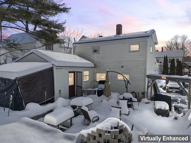 view of snow covered rear of property