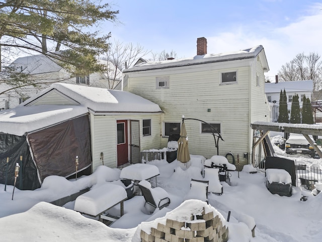 view of snow covered rear of property