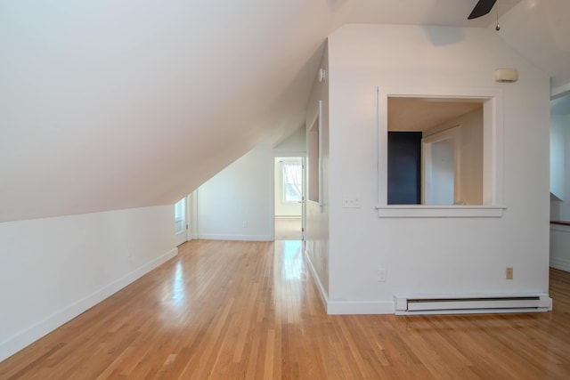 bonus room featuring baseboard heating, ceiling fan, vaulted ceiling, and light wood-type flooring