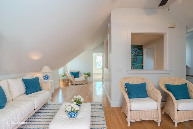 living room featuring ceiling fan, vaulted ceiling, and light wood-type flooring