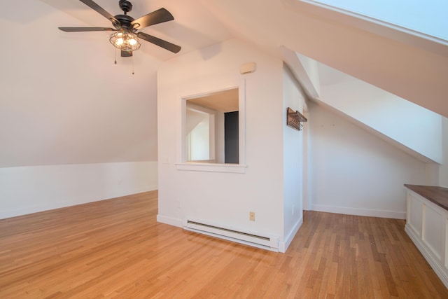 bonus room featuring light wood-type flooring, ceiling fan, vaulted ceiling, and a baseboard heating unit