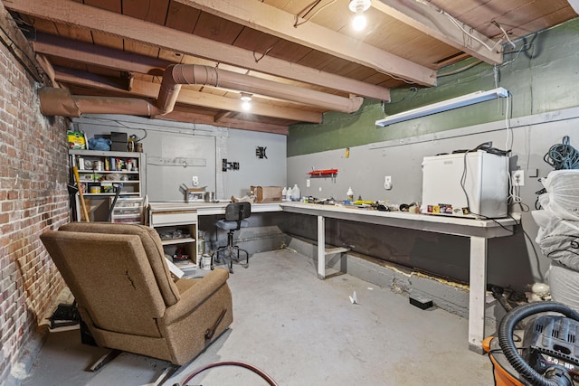 interior space featuring concrete flooring, brick wall, and a workshop area