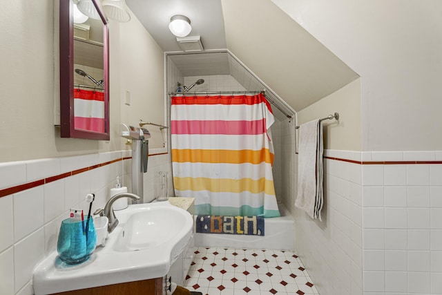 bathroom featuring wainscoting, tile walls, vanity, and shower / bath combo with shower curtain