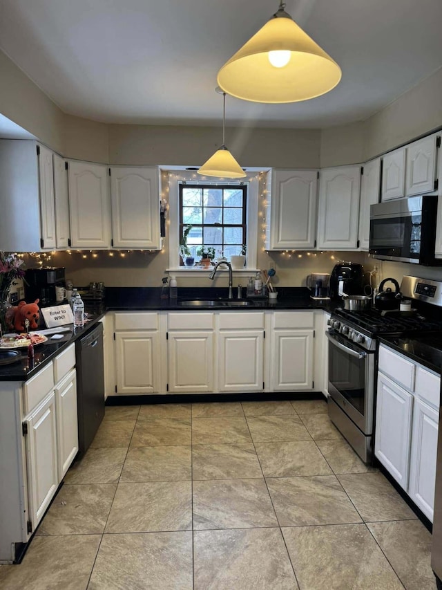 kitchen featuring stainless steel appliances, white cabinets, and decorative light fixtures