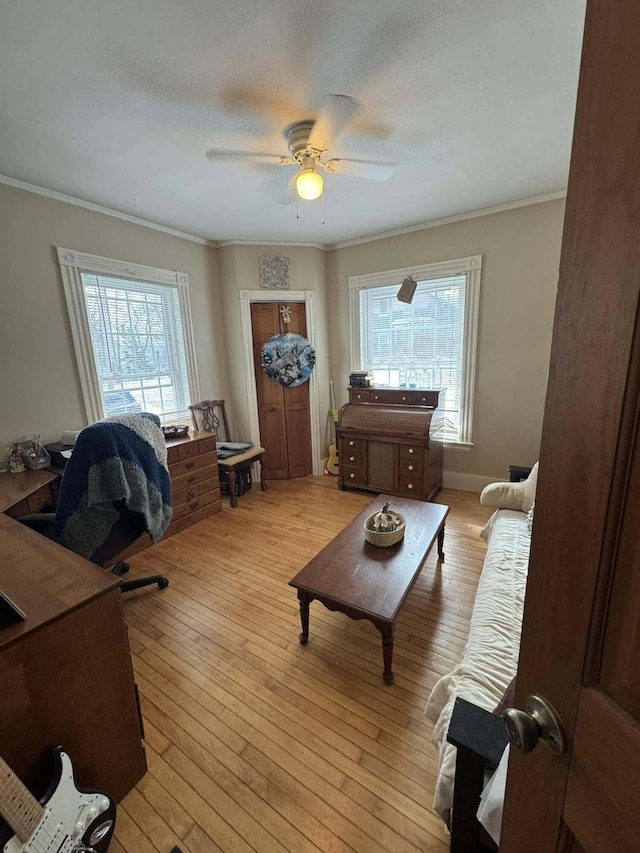 interior space with ornamental molding, plenty of natural light, light wood finished floors, and a ceiling fan