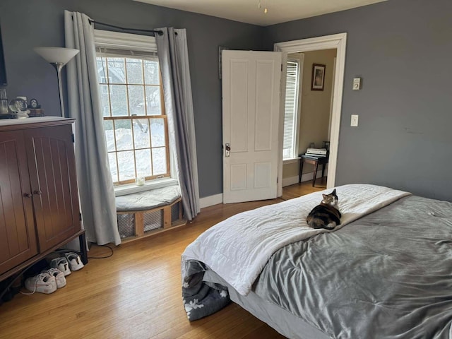 bedroom with light wood-type flooring and baseboards