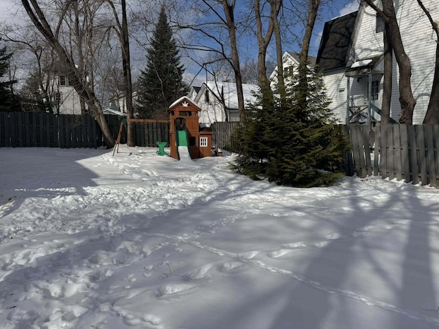 snowy yard with fence and a playground