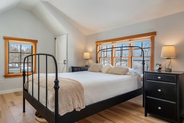 bedroom featuring light hardwood / wood-style floors and vaulted ceiling